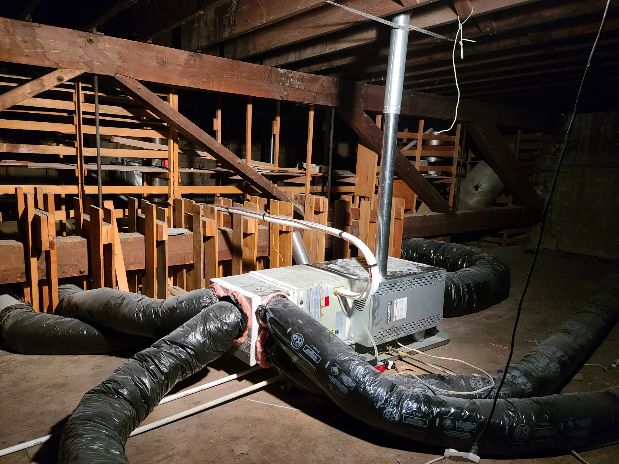 Commercial HVAC ductwork installation with insulated flex ducts and central air handler unit