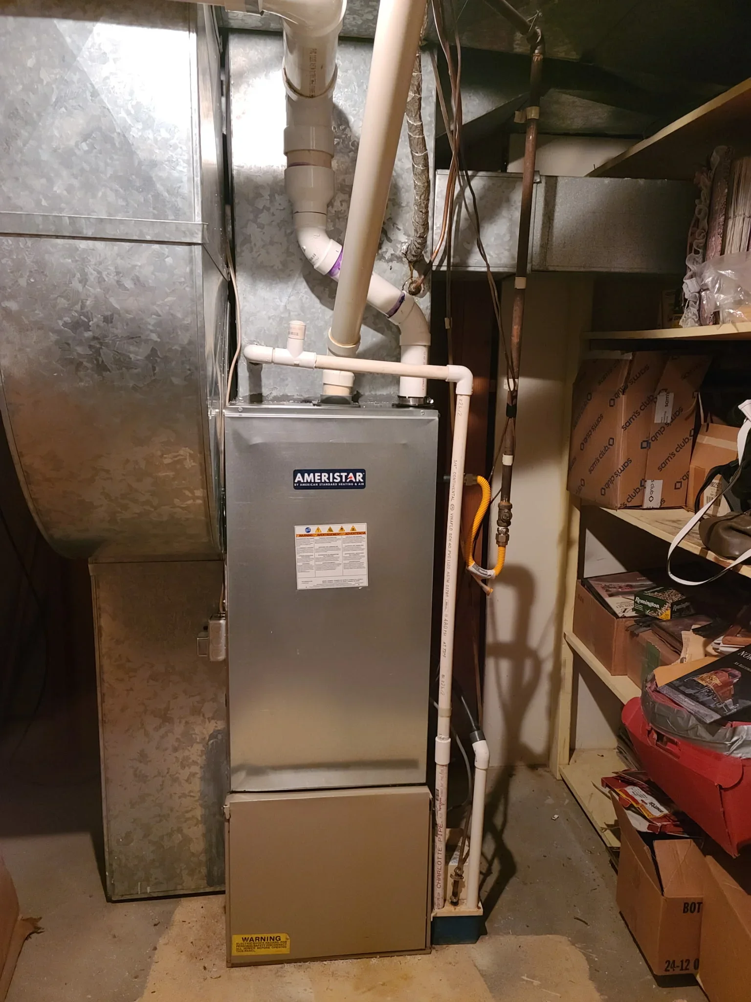 Newly installed Ameristar furnace with white PVC ducts and copper lines in basement utility room