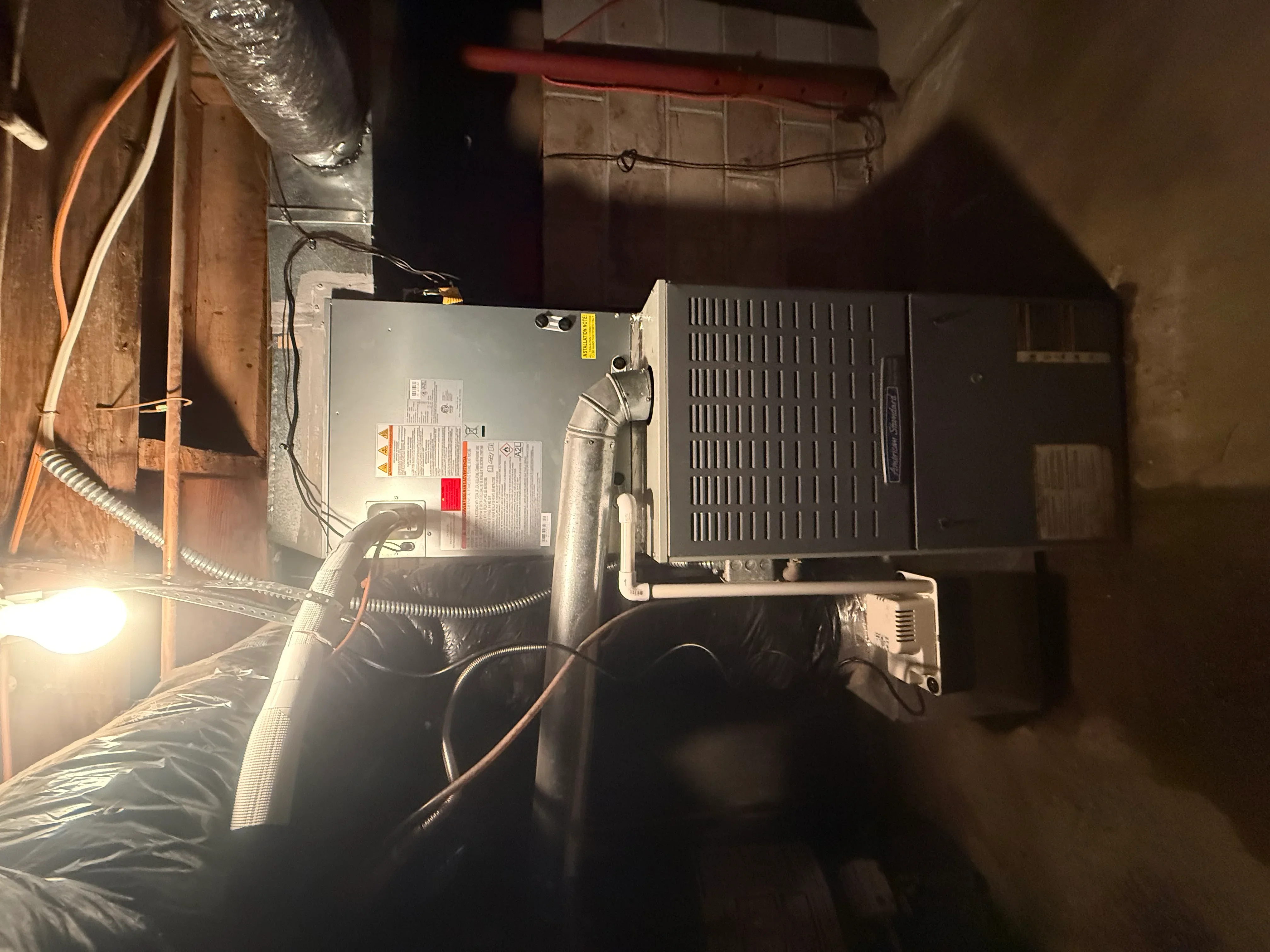 Commercial HVAC air handler unit installation with ductwork and refrigerant piping
